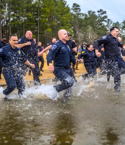 Police officers jumping into icy cold water