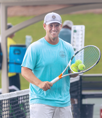 Man holding tennis racquet and tennis balls