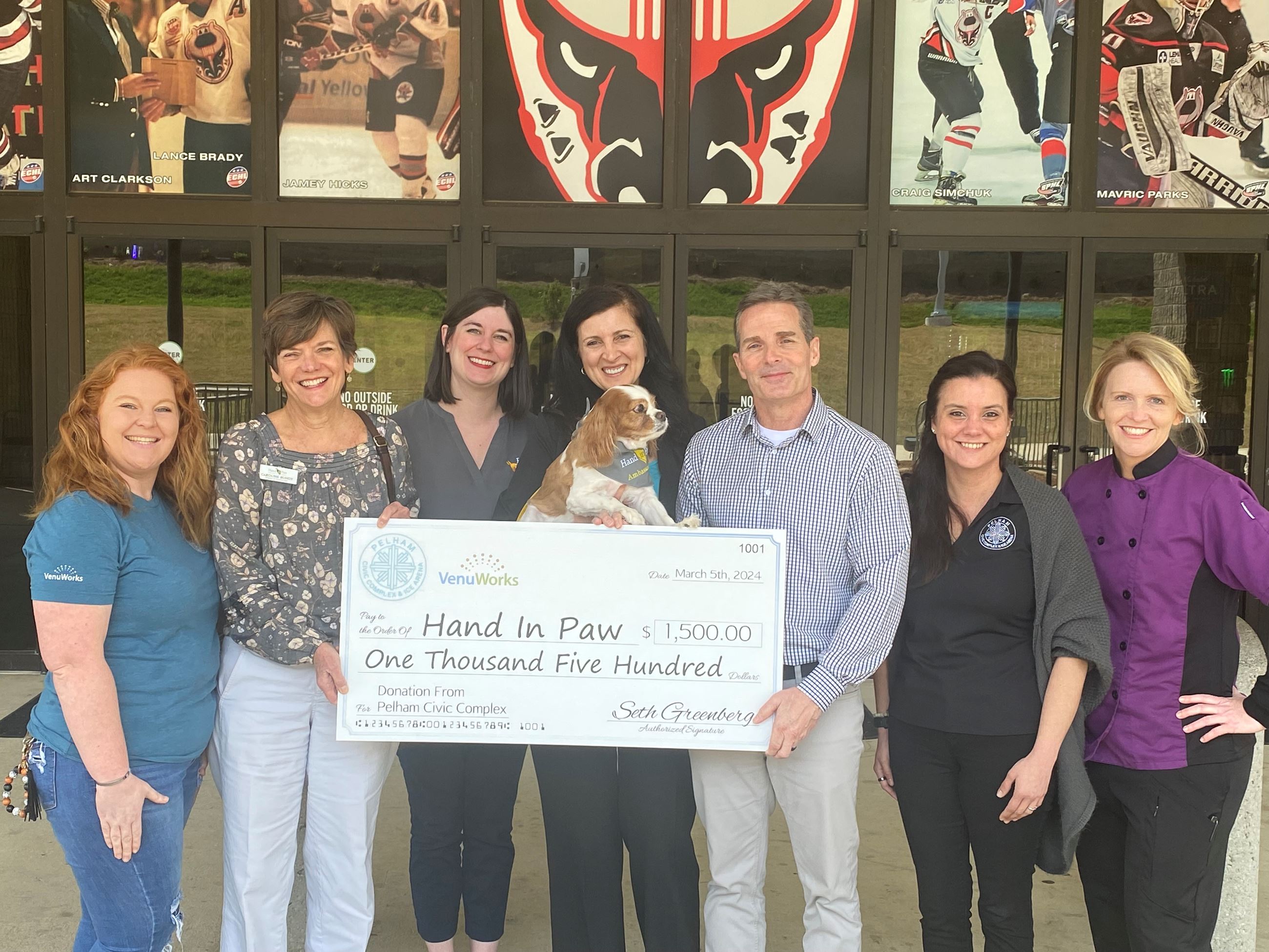 Members of the Pelham Civic Complex & Ice Arena present a check to Hand In Paw.